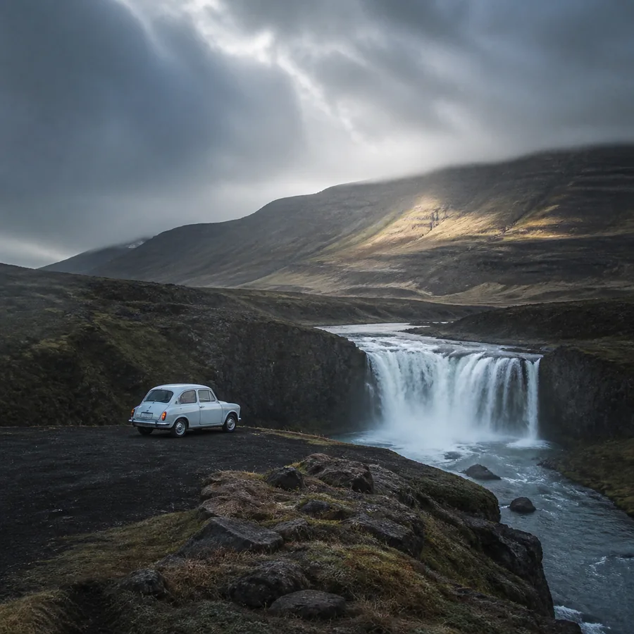 Une cascade et une petite voiture au milieu des montagnes d’Islande